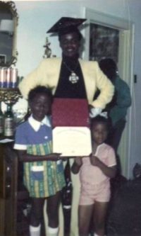 a picture of a man in a graduation cap with two children holding his diploma